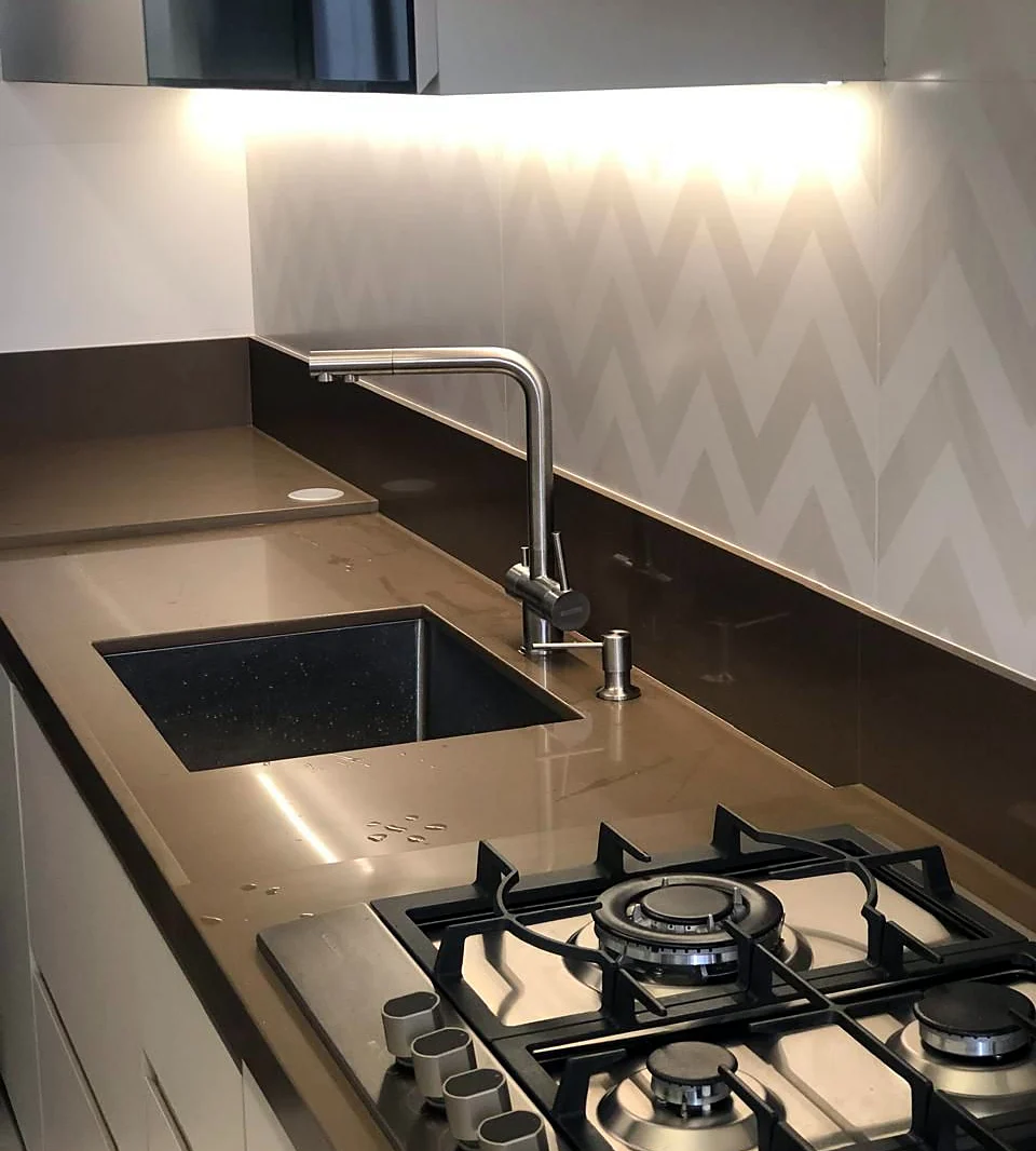 Bancada de cozinha com cooktop e revestimento em chevron