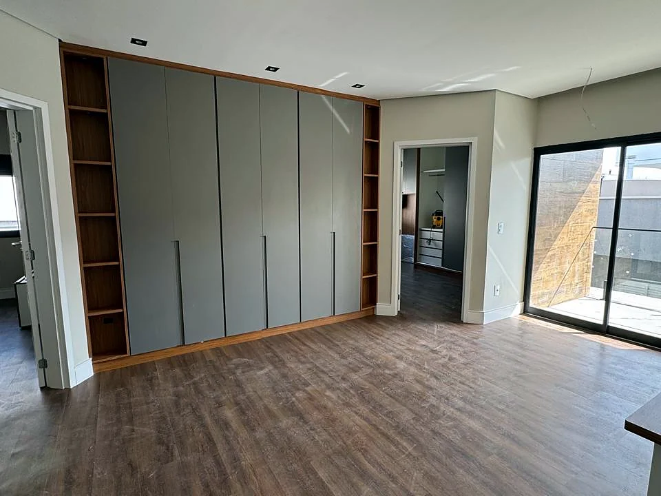 Quarto com armários planejados, piso em madeira e porta de vidro, obra executada pela HSM Engenharia